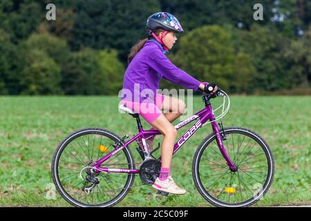 Kind auf Fahrradweg, Mädchen fahren einen Fahrradhelm, Kind reiten Fahrrad mit Helm Stockfoto