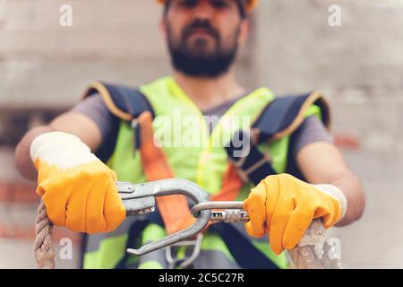 Arbeiten in der Höhe der Ausrüstung. Fallschutzvorrichtung für Arbeiter mit doppelten Haken für Sicherheitsgurt auf selektive Fokussierung. Die Konstruktion als Rückstand Stockfoto