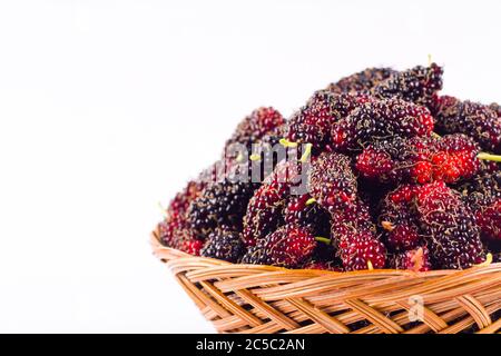 Reife Maulbeere in braunem Korb ist eine Frucht mit Vitaminen. Auf weißem Hintergrund gesunde Maulbeerfrucht Nahrung isoliert Stockfoto