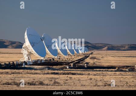 Eine Reihe von Radioteleskopschalen standen alle am Very Large Array (VLA) in der hohen Wüste von New Mexico auf Stockfoto