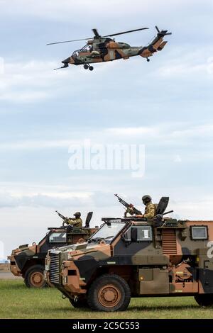 Zwei Panzerpanzer (APC) der australischen Armee mit einem Army Eurocopter Tiger Hubschrauber, der Luftabdeckung bietet. Stockfoto