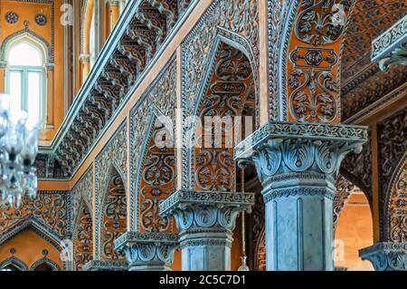 Verzierte Stuckarbeiten und aufwändige Schnitzereien an den Bögen der Säulen in Nizams Wohnstätte im Chowmahalla Palace, Hyderabad, Telangana, Indien. Stockfoto