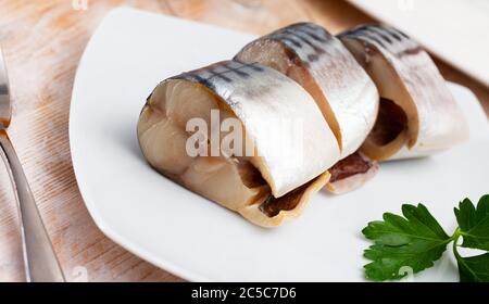 Beliebte Vorspeise aus leicht gesalzenen Makrelen Scheiben mit Grüns auf weißem Teller Stockfoto