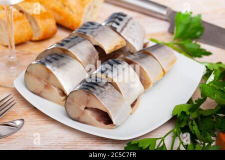 Beliebte Vorspeise aus leicht gesalzenen Makrelen Scheiben mit Gemüse und frischem Brot auf weißem Teller Stockfoto