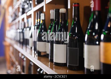 Regale mit verschiedenen roten und weißen Weinflaschen in einem großen Weinladen Stockfoto