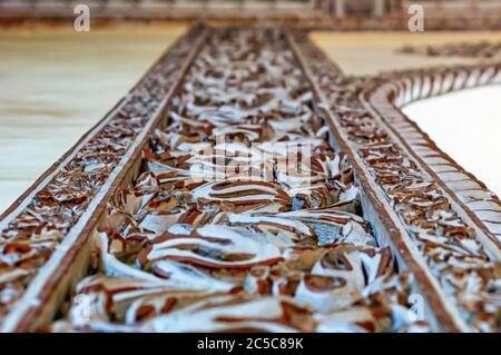 Eine Nahaufnahme der komplizierten Schnitzereien auf den Steinsäulen am Eingang von Nizams Wohnung im Chowmahalla Palast, Hyderabad, Telangana, Indien. Stockfoto