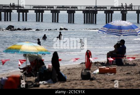 New York, USA. Juli 2020. Menschen schwimmen im Meer an einem Strand in Coney Island in New York City, USA, 1. Juli 2020. Am Mittwoch sind acht Strände in New York offiziell zum Schwimmen geöffnet, wenn Rettungsschwimmer täglich von 10 bis 18 Uhr im Einsatz sind.Quelle: Wang Ying/Xinhua/Alamy Live News Stockfoto