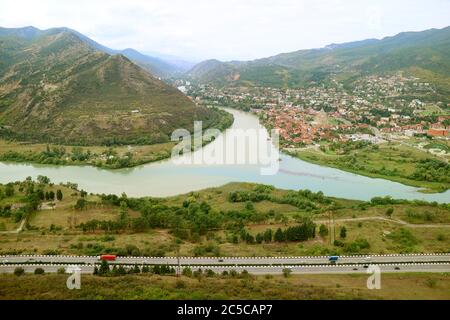 Atemberaubende Luftaussicht auf den Fluss Mtkvari trifft auf den Fluss Aragvi mit der Kathedrale Svetizchoveli rechts, vom Jvari-Kloster aus gesehen, Mzcheta, Georgien Stockfoto