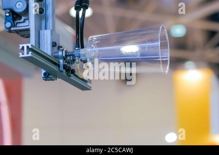 Automatische Pick-and-Place-Roboter-Arm-Manipulator mit Saugnäpfen bewegt Polypropylen-Tasse - Teil der Kunststoff-Spritzgießmaschine auf der Ausstellung Stockfoto