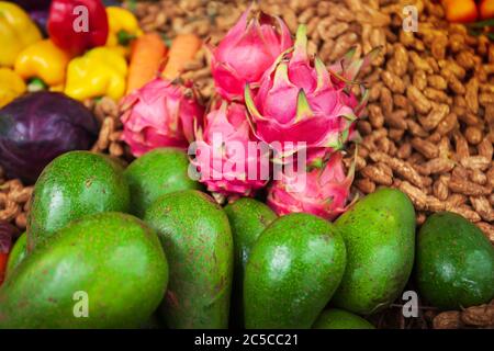 Frische rohe und reife Drachenfrüchte, Avocados, purpurne Cabbages und andere Früchte und Gemüse aus ökologischem Anbau. Konzentrieren Sie sich auf Drachenfrucht. Stockfoto