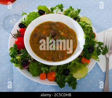 Appetitlich Gulasch mit Huhn Herz in Weiß Schüssel mit grünen und Kalk serviert. Stockfoto