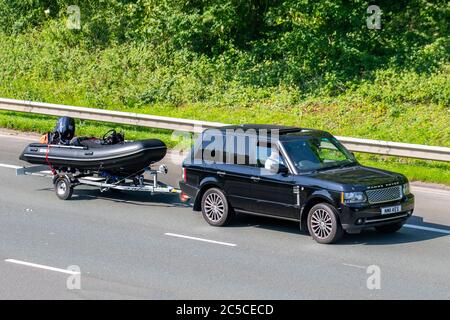 2011 Black Land Rover Range Rover Vogue se ; Fahrzeuge, die den Verkehr bewegen, Autos, die Bootsanhänger schleppen, Fahrzeuge auf britischen Straßen fahren, Motoren, die mit BRIG-Schlauchbooten geschleppt werden, Fahrzeuge, die auf dem Autobahnnetz der M6 fahren. Stockfoto