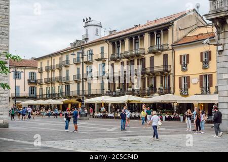 Menschen auf der Piazza del Duomo an bewölktem Sommertag. Cafe und Restaurants vor der Kathedrale (der Dom), alte Häuser im Hintergrund. Stockfoto