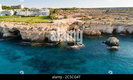 Luftaufnahme der Küste und Wahrzeichen Love Bridge, internationaler Skulpturen Park und Meereshöhlen, Cavo Greco, Ayia Napa, Famagusta, Zypern von oben. Stockfoto