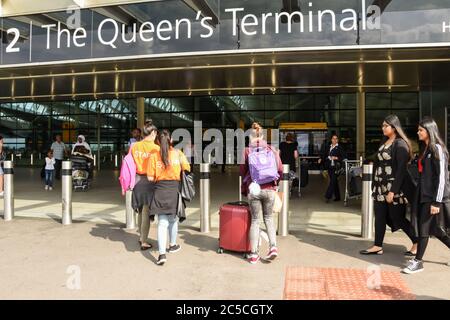 Passagiere und Mitarbeiter, die das Queens Terminal, den Flughafen Heathrow, London, Großbritannien, betreten und verlassen Stockfoto