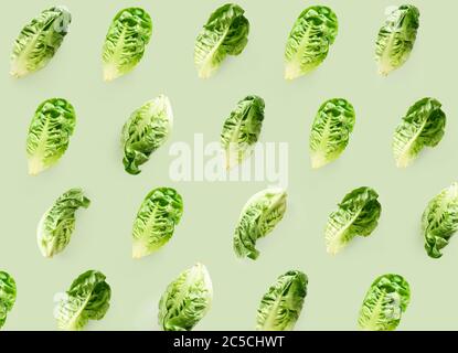 Kreatives Nahtloses Muster mit frischen Romaine-Salatköpfen isoliert auf grünem Hintergrund. Stockfoto