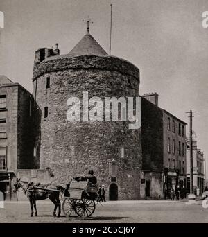 Ein Blick auf ein Pony und eine Falle, die Anfang der 20er Jahre am Reginald's Tower in Waterford City vorbeireiten. Erbaut von den Anglo-Normannen, um eine frühere Wikingerbefestigung zu ersetzen, als Prinz John von England in Waterford landete und den Wiederaufbau der Stadtverteidigung organisierte, einschließlich des Turms zwischen 1253 und 1280. Ursprünglich fotografiert von Clifton Adams (1890-1934) für 'Ireland: The Rock Whence I Was Hewn', eine National Geographic Magazine-Spielfilm vom März 1927. Stockfoto