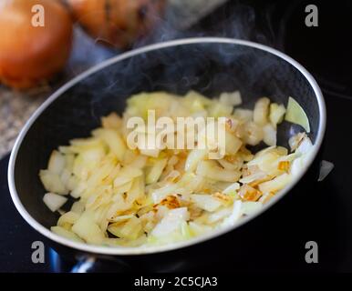 Gebratene Zwiebeln in einer Pfanne. Die gehackte Zwiebel in Öl rösten Stockfoto