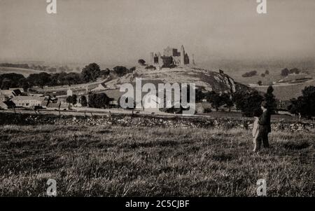 Eine Ansicht des Rock of Cashel, auch bekannt als Cashel der Könige und St. Patrick's Rock, aus den frühen 1920er Jahren. Eine historische Stätte in Cashel, Grafschaft Tipperary, es wurde als der Ort der Umwandlung des Königs von Münster durch St. Patrick im 5. Jahrhundert. Traditioneller Sitz der Könige von Münster mehrere hundert Jahre vor der Invasion der Normannen bis 1101 schenkte der König von Münster, Muirchertach UA Briain, der Kirche die Festung. Ursprünglich fotografiert von Clifton Adams (1890-1934) für 'Ireland: The Rock Whence I Was Hewn', eine National Geographic Magazine-Spielfilm vom März 1927. Stockfoto