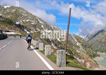 Rennradfahrer auf dem Grimselpass in den Schweizer Alpen, der das Berner Oberland mit dem Oberwallis, Schweiz, verbindet Stockfoto