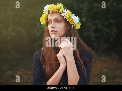 Outdoor-Porträt eines schönen Mädchen trägt einen Blumenkranz auf dem Kopf Stockfoto