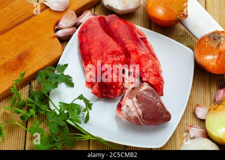 Bild von rohem Lamm Lunge und Herz serviert mit Gemüse während des Kochens Stockfoto