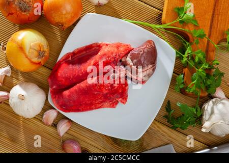 Bild von rohem Lamm Lunge und Herz serviert mit Gemüse während des Kochens Stockfoto