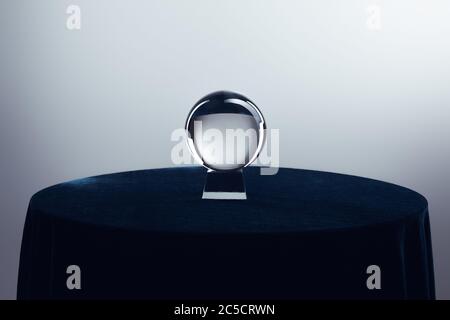 Kristallkugel auf runder Tisch auf grauem Hintergrund Stockfoto