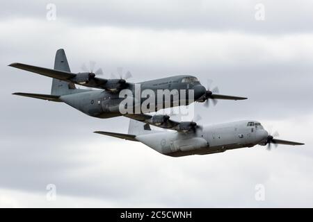 Zwei Royal Australian Air Force Lockheed Martin C-130J Hercules militärische Frachtflugzeuge fliegen in Formation. Stockfoto