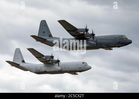 Zwei Royal Australian Air Force Lockheed Martin C-130J Hercules militärische Frachtflugzeuge fliegen in Formation. Stockfoto