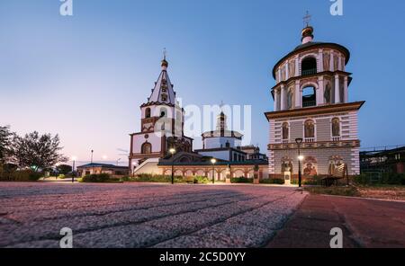 Russland, Irkutsk - 30. Juni 2020: Die Kathedrale der Erscheinung des Herrn. Orthodoxe Kirche, katholische Kirche in Sonnenuntergang mit Pflastersteinen Stockfoto