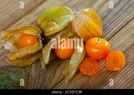 Gelbe reife Kapgansbeere (Physalis peruviana) ganz und halbiert Stockfoto