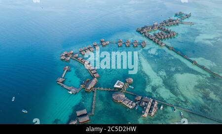 Luxusbungalows mit Booten angedockt und ein Heliport in der Nähe der Zimmer. Klares und türkisfarbenes Wasser. Stockfoto