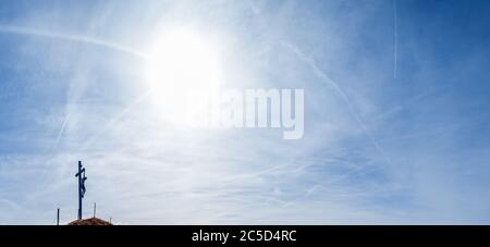 Christentum krycifix religiöse Jesus Christus alte Holzfigur auf blauem Himmel mit weißen flauschigen Cirrus und Cirrocumulus Wolken und Sonnenlicht leuchten backgrou Stockfoto