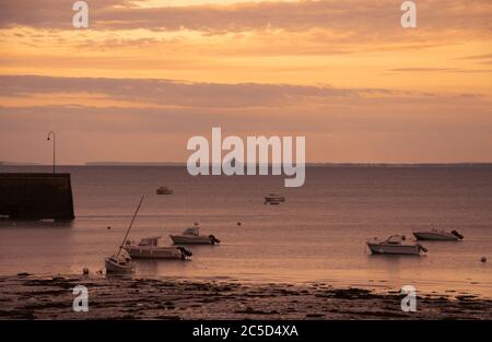 Cancale (Bretagne) bei Sonnenuntergang. Anlegestelle für Segelboote und Blick auf die traumhafte Silhouette des Mont Saint Michel am Horizont. Stockfoto