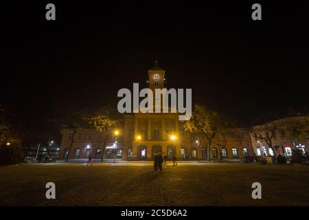 SOMBOR, SERBIEN - 19. NOVEMBER 2019: Rathaus von Sombor, auch gradska kuca genannt, nachts, während eines nebligen Abends, mit Fußgängern, die in Geschwindigkeit Bl Stockfoto
