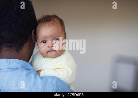 Nahaufnahme von niedlichen afrikanischen Baby Mädchen auf die Hände ihres Vaters Stockfoto