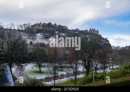 Blick auf das verschneite Edinburgh Castle und die Princes Street Gardens im Winter Stockfoto