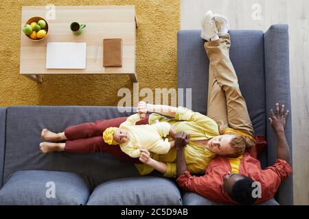 High-Winkel-Ansicht der Familie von drei Ruhe auf dem Sofa zusammen mit ihrem Baby Mädchen Stockfoto