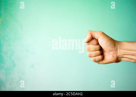 Hand des Mannes mit Faust auf grünem Hintergrund. Stockfoto