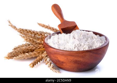 Mehl mit Weizen in einer Holzschale und Schaufel auf weißem Hintergrund. Nahaufnahme, Seitenansicht, hochauflösende Produktabbildung. Stockfoto