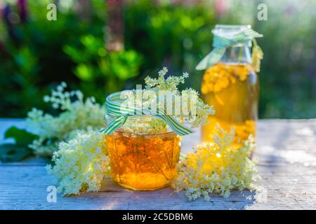 Infusion von Holunderblüten in einem Glas auf dem Gartentisch. Stockfoto