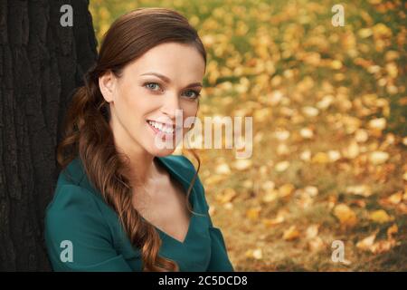 Glückliche lächelnde Frau im Park. Hübsches Mädchen im Freien Porträt Stockfoto