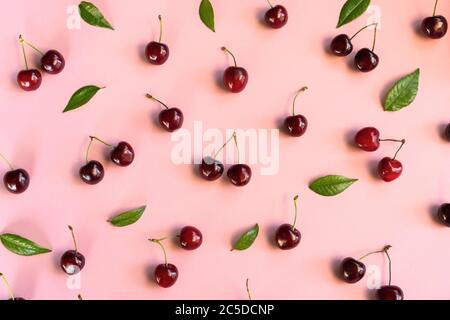 Kirschmuster. Flache Kirschenlage auf rosa Hintergrund. Draufsicht. Stockfoto