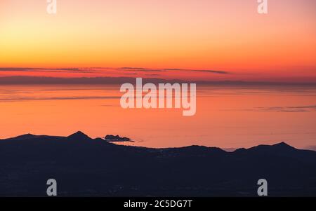 Sonnenuntergang über Ile Rousse und dem Mittelmeer an der Westküste Korsikas mit der Silhouette des französischen Festlandes in der Ferne Stockfoto