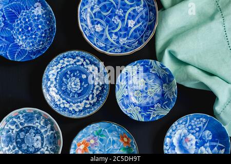 Blau und weiß dekorative japanische Keramik-Platten auf schwarzem Hintergrund - Draufsicht Foto Stockfoto