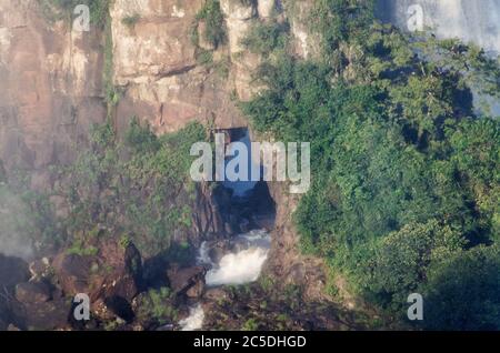 Iguacu Falls, Brasilien - ein Wasserfall mit Nebel bedeckt, der durch einen Bogen im Felsen bricht Stockfoto