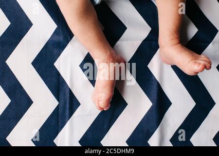 Füße und Beine des Neugeborenen. Zart und zerknittert. Schwache und kratzende Füße. Stockfoto