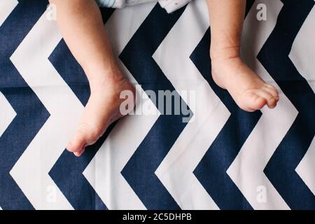 Füße und Beine des Neugeborenen. Zart und zerknittert. Schwache und kratzende Füße. Stockfoto