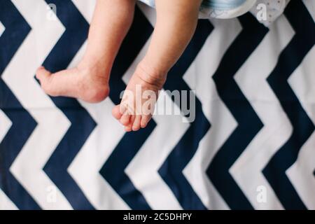 Füße und Beine des Neugeborenen. Zart und zerknittert. Schwache und kratzende Füße. Stockfoto